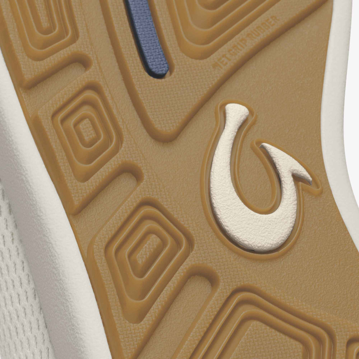 White and cream slip-on shoe sole with blue fabric strip and textured tan outsole with hook logo detail.