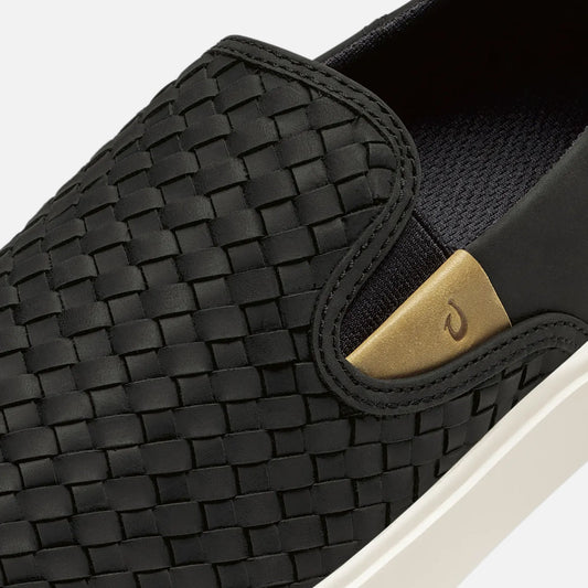 Black woven leather slip-on shoe with gold metal accent and white sole.