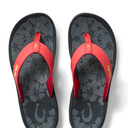 Red flip-flops with floral patterned dark gray footbed and gold script text on strap.