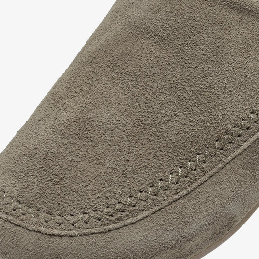 Gray suede material with curved seam detail and textured surface.