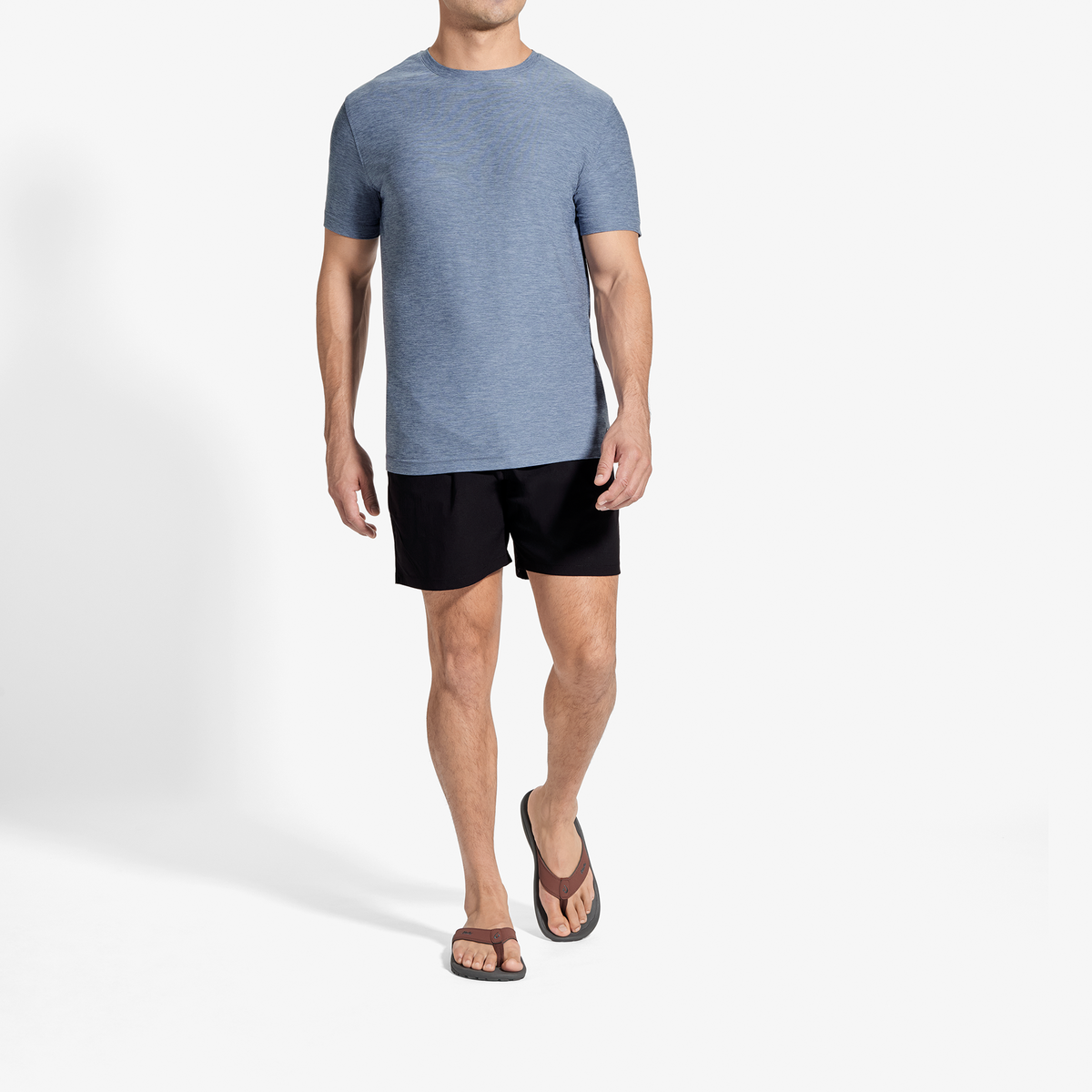 Man wearing blue heather t-shirt and black shorts with brown sandals.