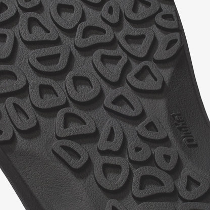Dark gray rubber sole with textured tread pattern featuring curved cutout design.