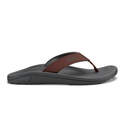 Flip-flop with gray foam sole and brown leather thong strap, side view.