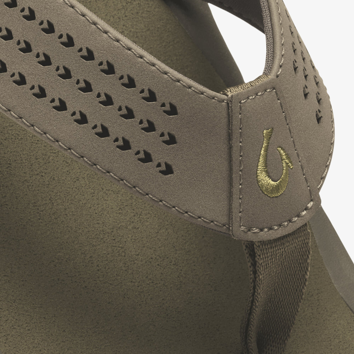 Tan suede hobo bag with perforated detailing and embroidered horseshoe logo on shoulder strap.