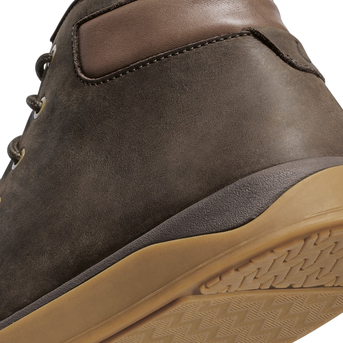 Dark brown suede hiking boot with tan rubber sole and lace-up closure, shown from heel angle.
