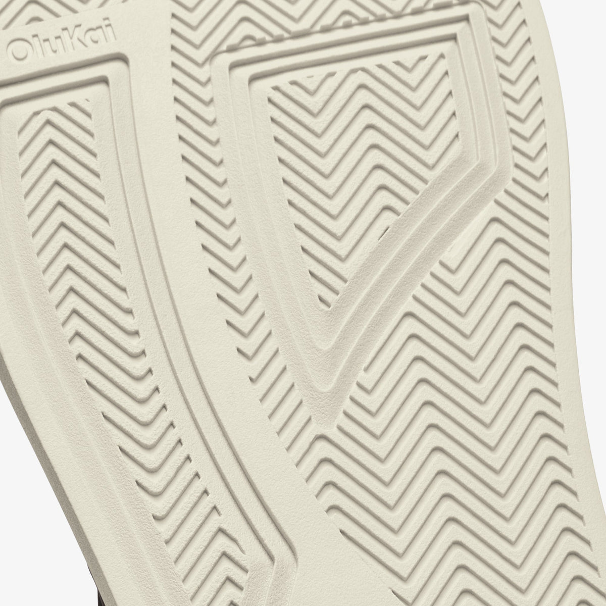 Cream-colored shoe sole with geometric chevron tread pattern and brand marking.