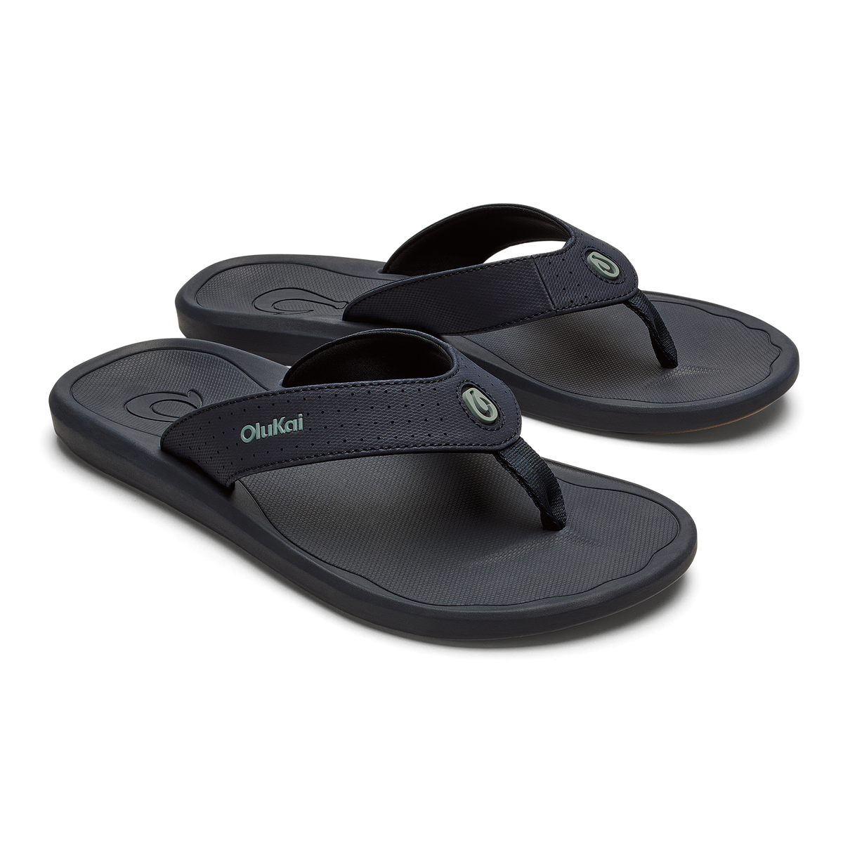 Pair of dark blue OluKai Ki'i flip-flops with textured footbeds and fabric thong straps.