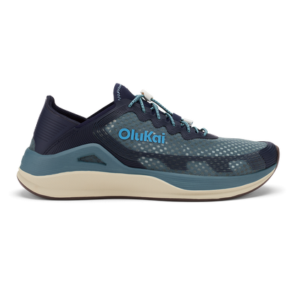 OluKai ʻAhi running shoe in storm and trench blue with cream midsole and teal accents.