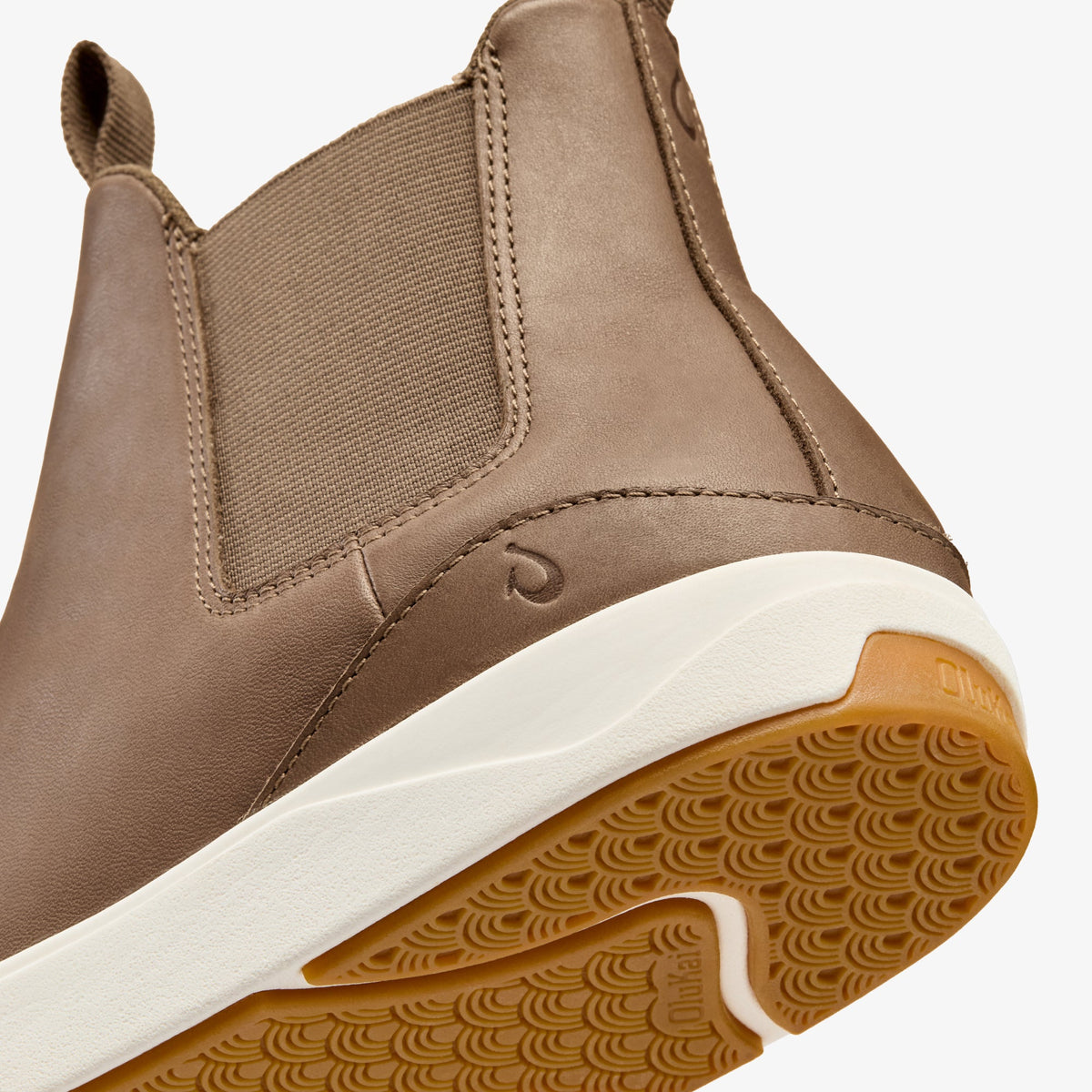 Beige leather Chelsea boot with elastic side panels, white midsole, and patterned tan rubber sole.