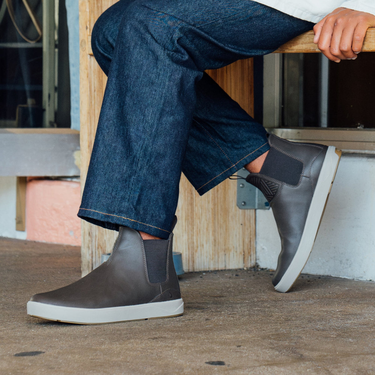 Dark navy jeans with dark gray and white slip-on boots worn with rolled cuffs.
