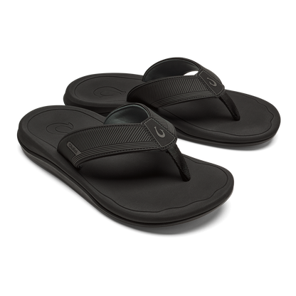 Pair of black thong sandals with textured straps and cushioned soles, shown from a three-quarter view.