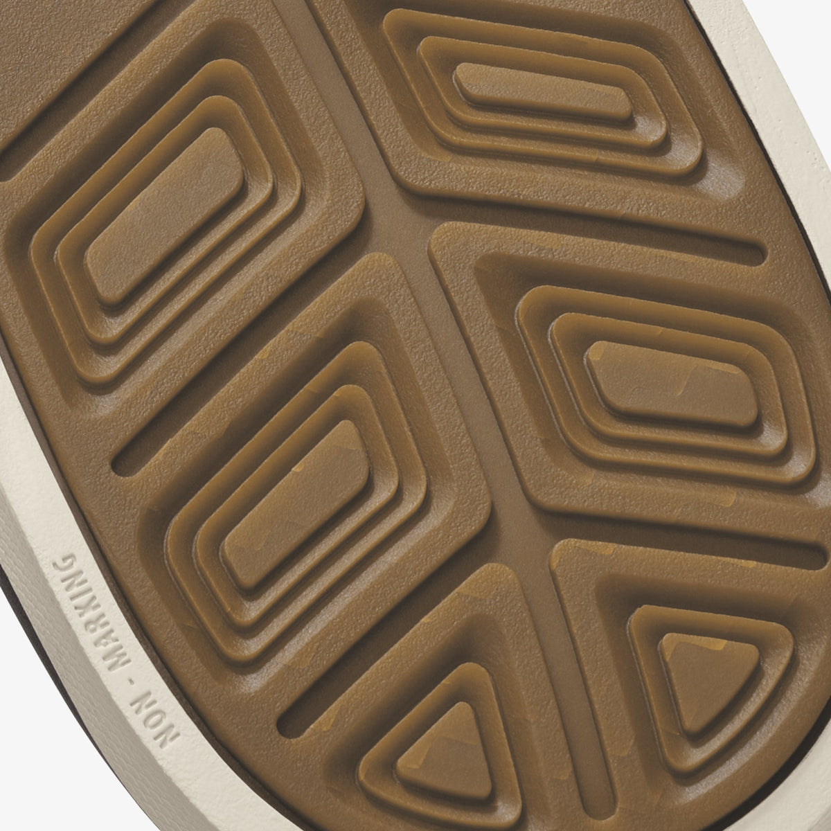 Tan and white shoe sole with geometric rectangular and triangular tread pattern.