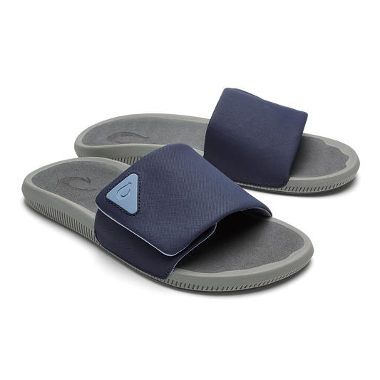Blue Depth and charcoal slide sandals with adjustable straps and gray textured footbeds.