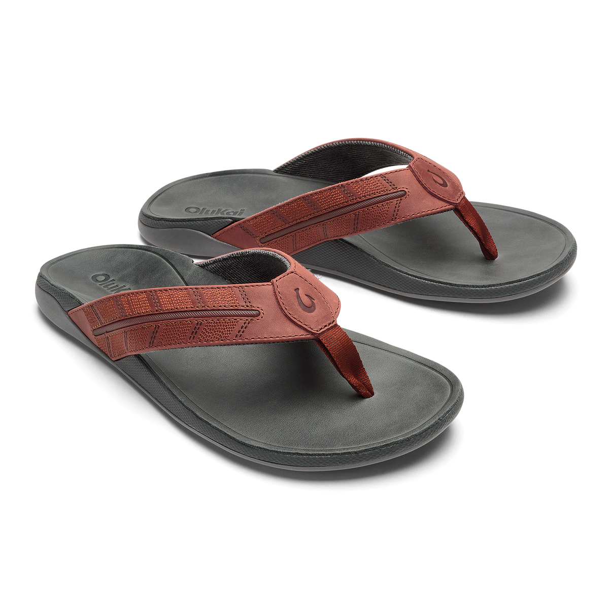 Pair of flip-flops with gray footbeds and rust-colored textured straps with circular buckle details.