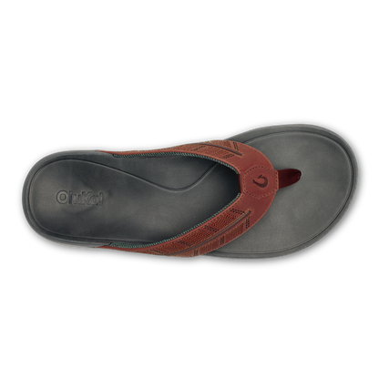 Charcoal gray thong sandal with rust-colored woven upper strap and button detail, viewed from above.