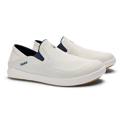 White and navy blue slip-on shoe with textured mesh upper and white cushioned sole.