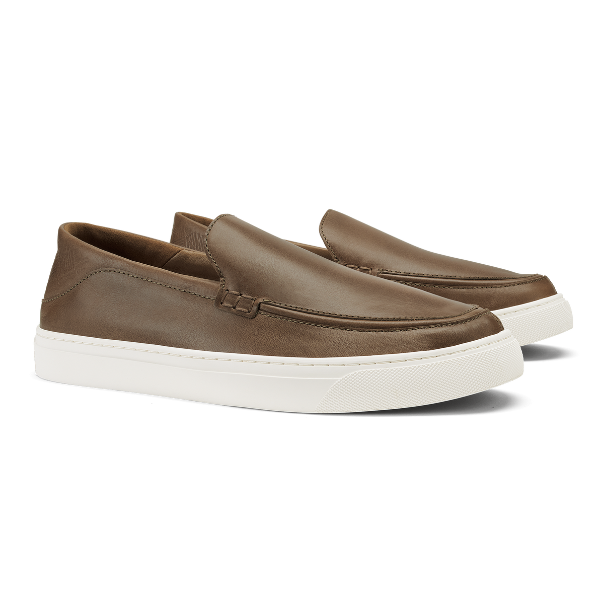 Walnut slip-on loafers with white rubber sole and stitched moc-toe detail.