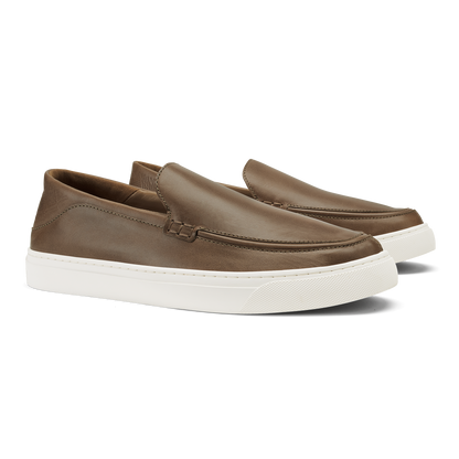 Walnut slip-on loafers with white rubber sole and stitched moc-toe detail.