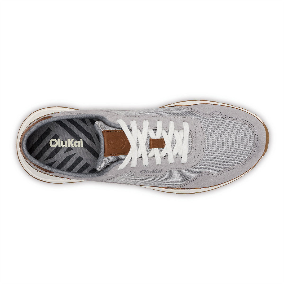Light grey OluKai sneaker with white laces, brown heel tab, and striped insole visible from above.