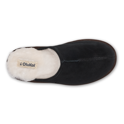 Black suede slipper with cream fleece lining and visible OluKai brand label, top view.