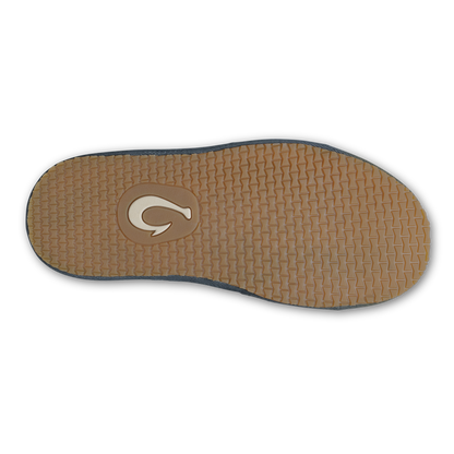 Sole of shoe with tan textured surface, dark shadow edge trim, and curved logo emblem.