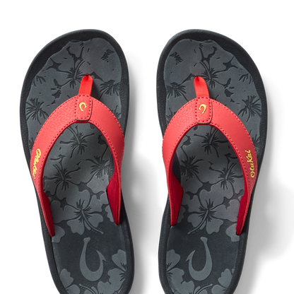 Red flip-flops with floral patterned dark gray footbed and gold script text on strap.