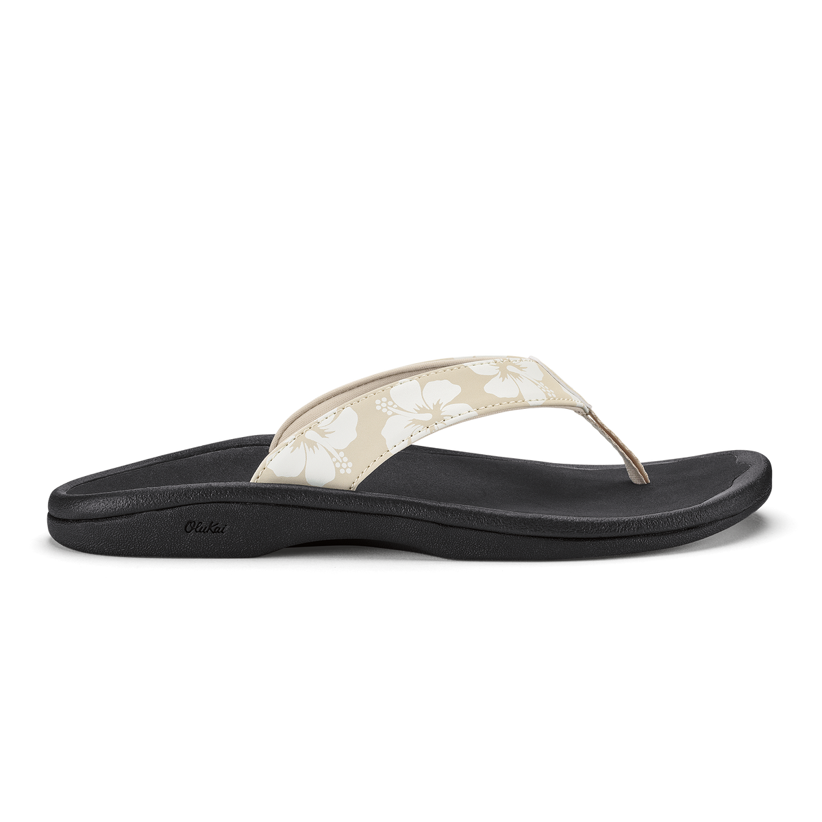 Black flip-flop sandal with beige thong strap featuring white floral pattern and dotted design.