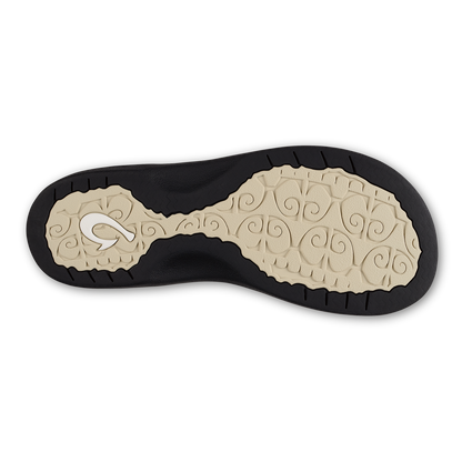 Black and cream shoe sole with scrolled tapa pattern and tread detail on bottom surface.