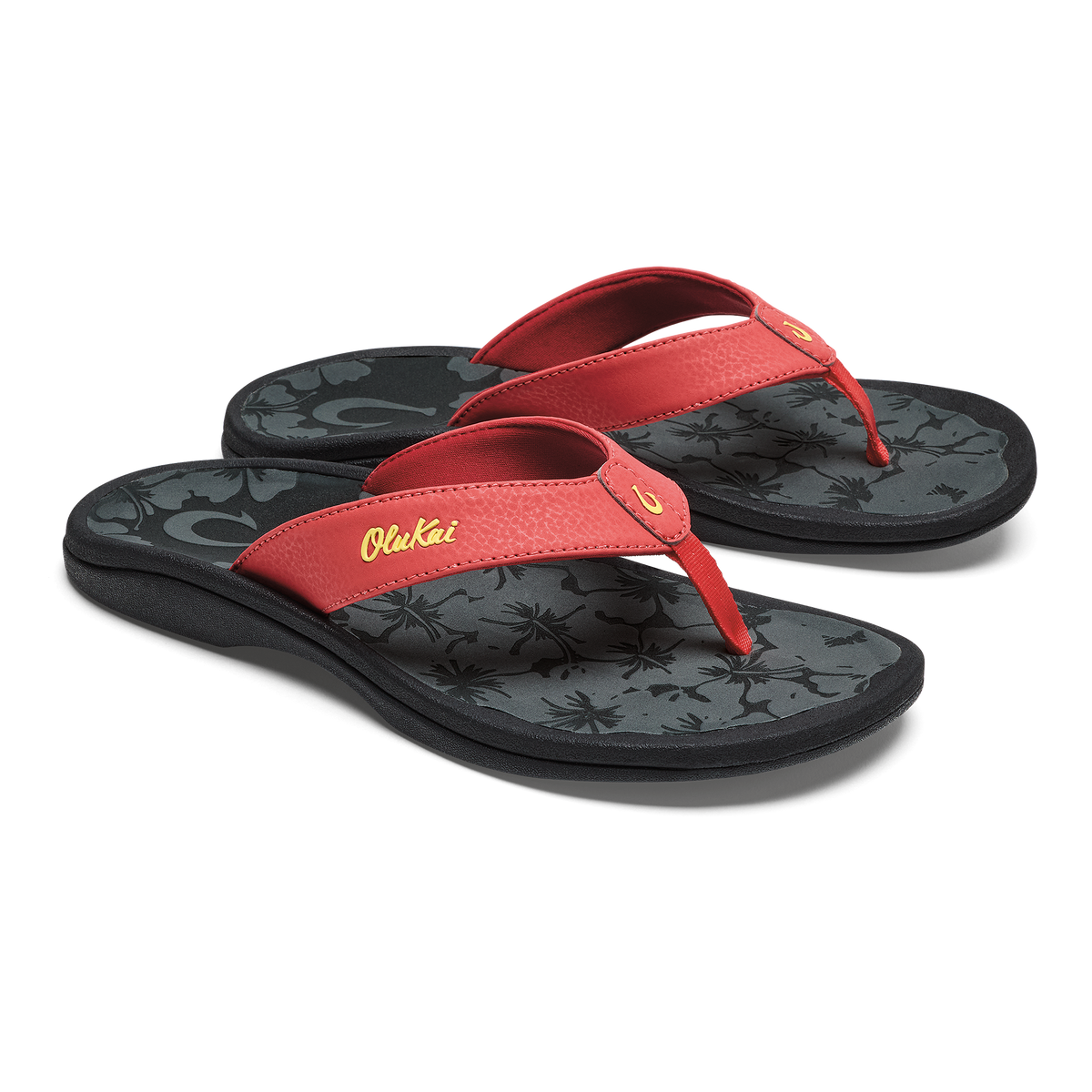 Red thong flip-flops with black patterned footbeds and yellow script text on the straps.