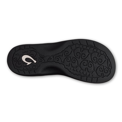 Black shoe sole with ornate swirl pattern and white logo on heel.