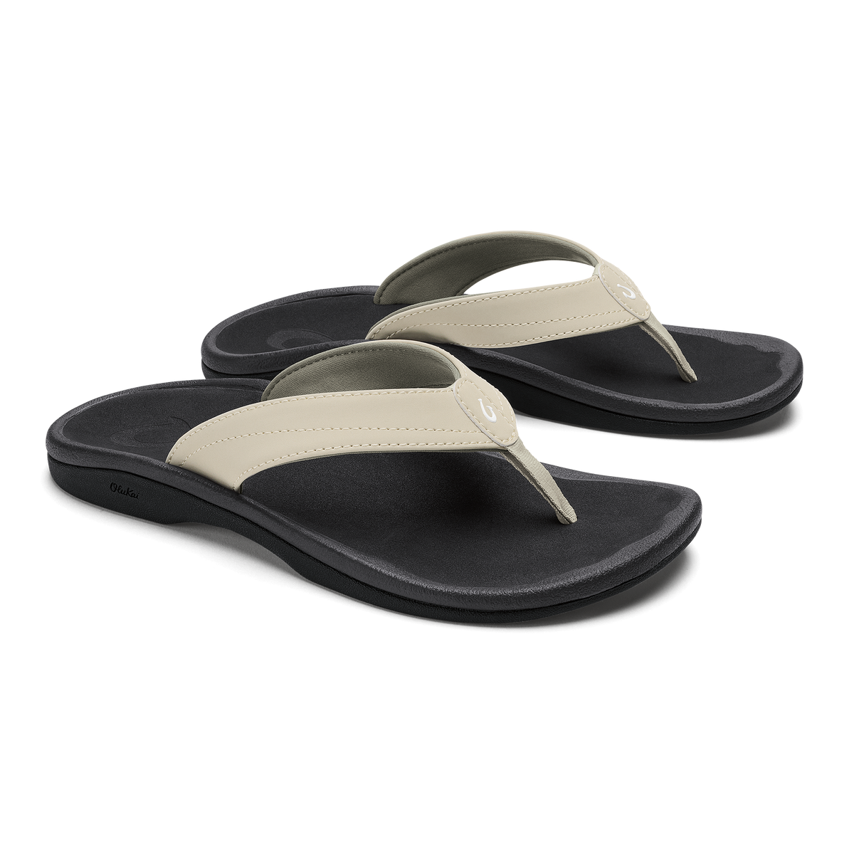 Pair of ecru and black flip-flop sandals with cushioned black soles and thong straps.
