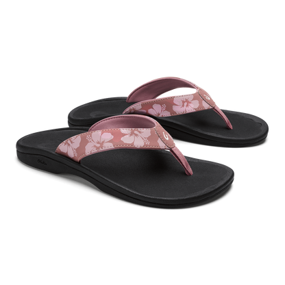 Pair of coral rose flip-flops with black soles and floral-patterned straps.