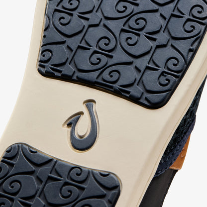 Shoe sole with cream-colored midsole, dark blue textured tread pattern, and embossed horseshoe logo.