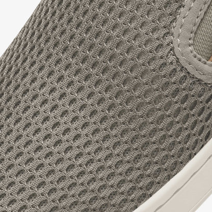 Taupe grey slip-on shoe with textured knit mesh upper and white sole.