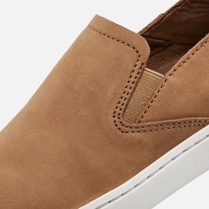 Tan leather slip-on shoe with brown quilted lining, elastic gore detail, and white sole.