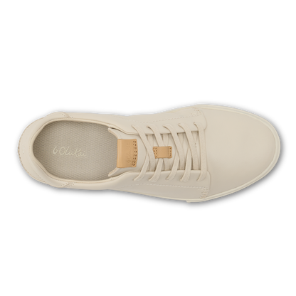 Cream canvas sneaker with tan leather heel tab and white laces, shown from above.