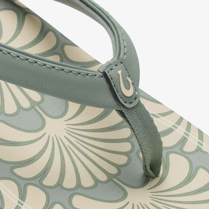 Sage green handbag with cream fan-print pattern and adjustable handle with curved metal accent.