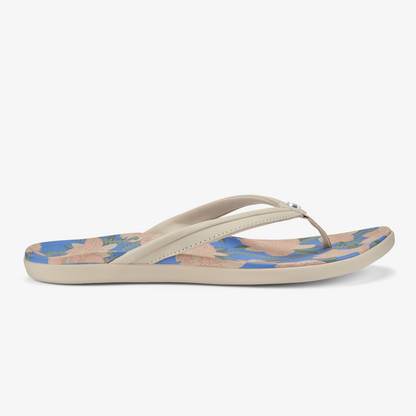 Cream and blue flip-flop with tapa floral pattern on footbed and marine blue sole.