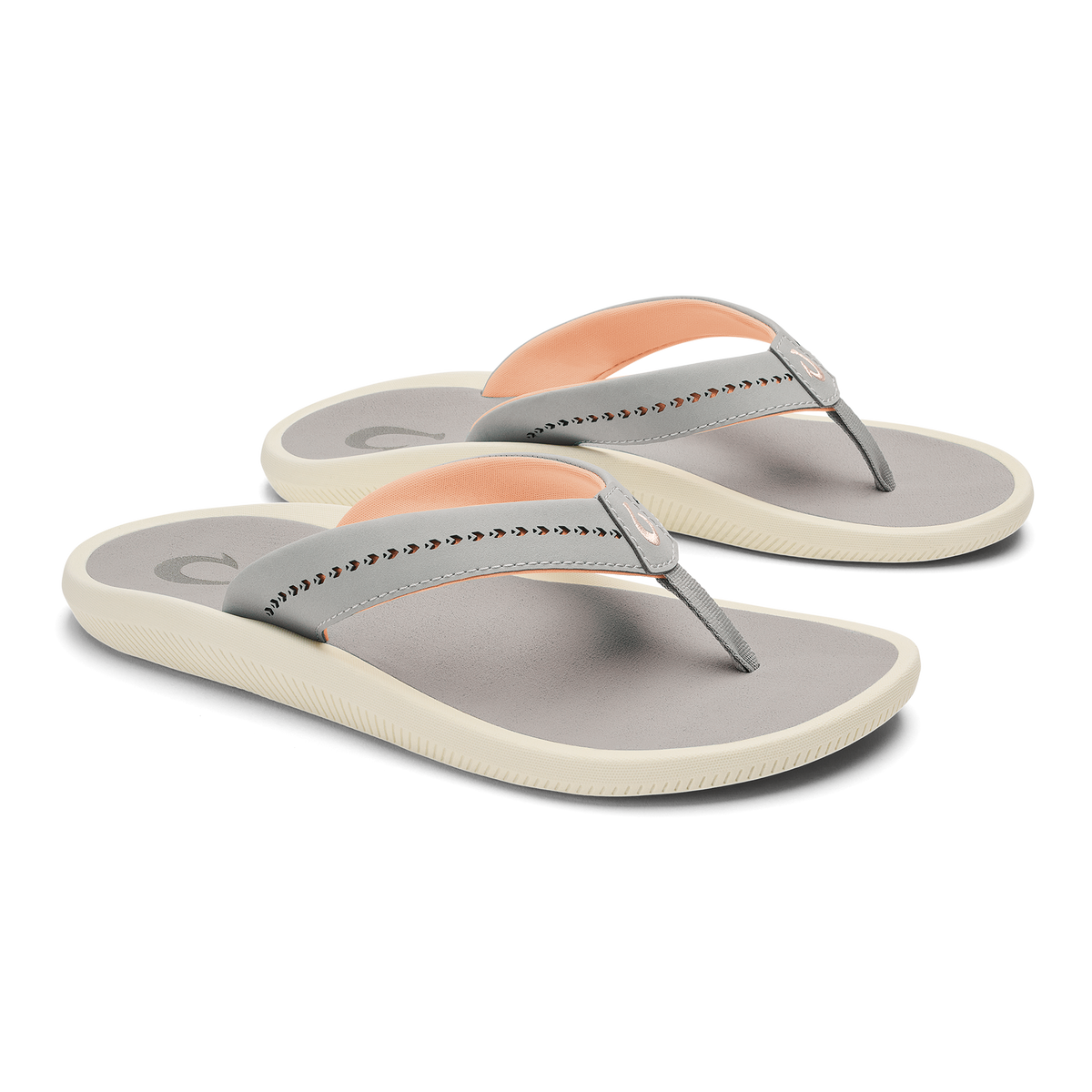 Pair of gray and cream flip-flop sandals with studded straps and peach-colored heel accents.
