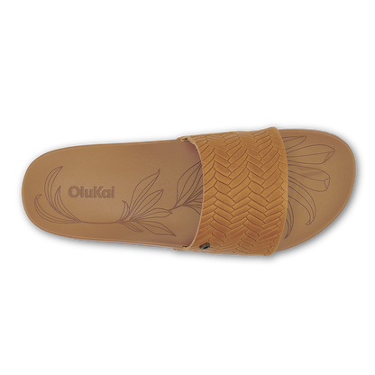 Tan slide sandal with woven upper strap and embossed leaf design on sole.