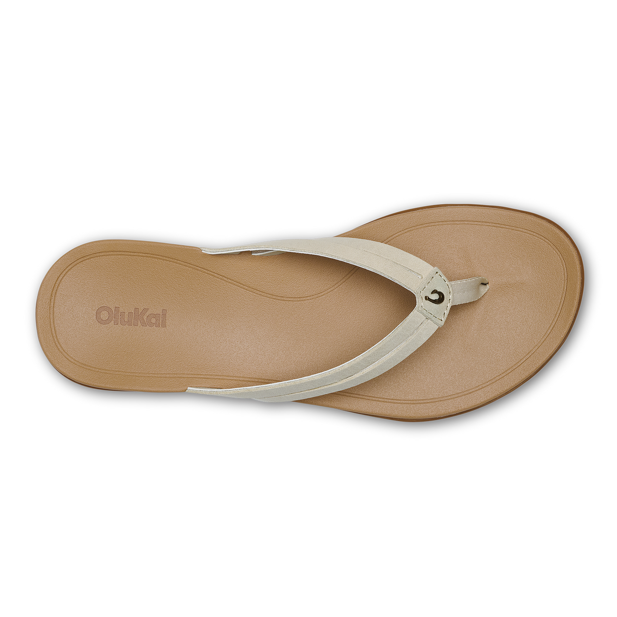 Tan flip-flop sandal with cream-colored thong strap and embossed OluKai logo on sole, viewed from above.