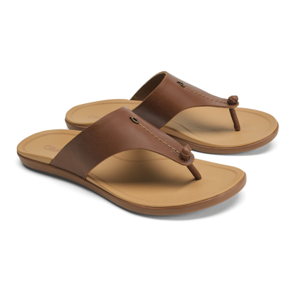 Pair of brown leather thong sandals with tan soles and decorative button details on the straps.
