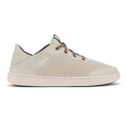 Cream-colored low-top sneaker with perforated mesh upper, brown laces, and cream rubber sole.