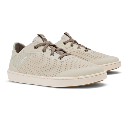Cream-colored lace-up sneaker with brown laces, perforated upper, and cream sole, shown from a three-quarter view.