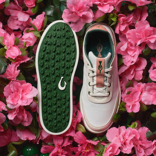 White canvas sneaker with white laces and rust-colored heel tab, shown from top and bottom sole views with green patterned so