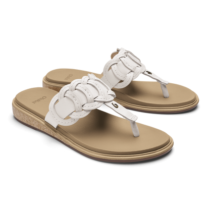 Pair of white and tan thong sandals with braided leather straps and cork wedge soles.