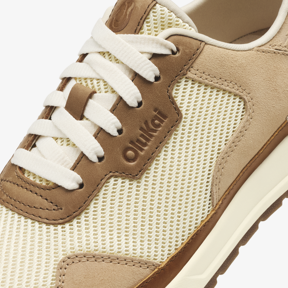 Tan and cream sneaker with mesh panels, suede overlays, white laces, and "Oulkad" branding on the side.