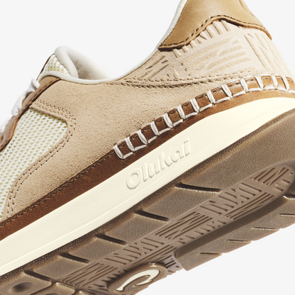 Beige and cream suede sneaker with brown stripe, white sole, and textured midsole detail.