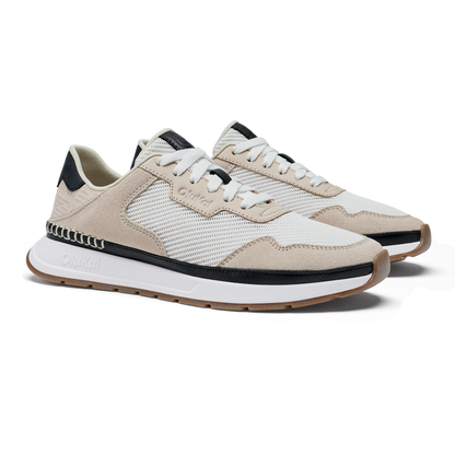 Pair of white and ecru sneakers with black heel accents and white sole.