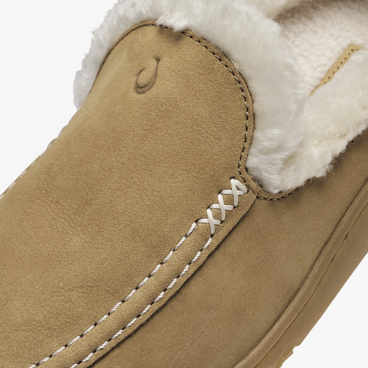 Tan suede slipper with white fleece lining and white cross-stitch detail along the side seam.